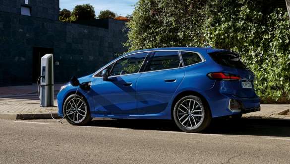 BMW Serija 2 Active Tourer 230e plug-in hibrid U06 2021 parkirano vozilo na stanici za punjenje električnom energijom BMW Serija 2 Active Tourer 230e plug-in hibrid U06 2021 M Portimao plave metalik boje bočni prikaz parkiranog vozila na stanici za punjenje električnom energijom