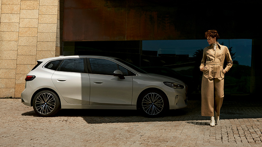 BMW Serija 2 Active Tourer U06 2021 bočni prikaz sa modelom BMW Serija 2 Active Tourer U06 2021 Mineral bela metalik boja bočni prikaz parkiranog vozila s modelom