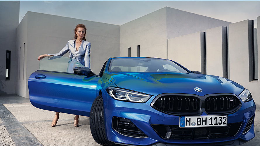 BMW M850i xDrive Coupé G15 LCI Facelift 2022 M Portimao plave metalik boje prednji prikaz parkiranog vozila sa modelom ispred otvorenih vrata