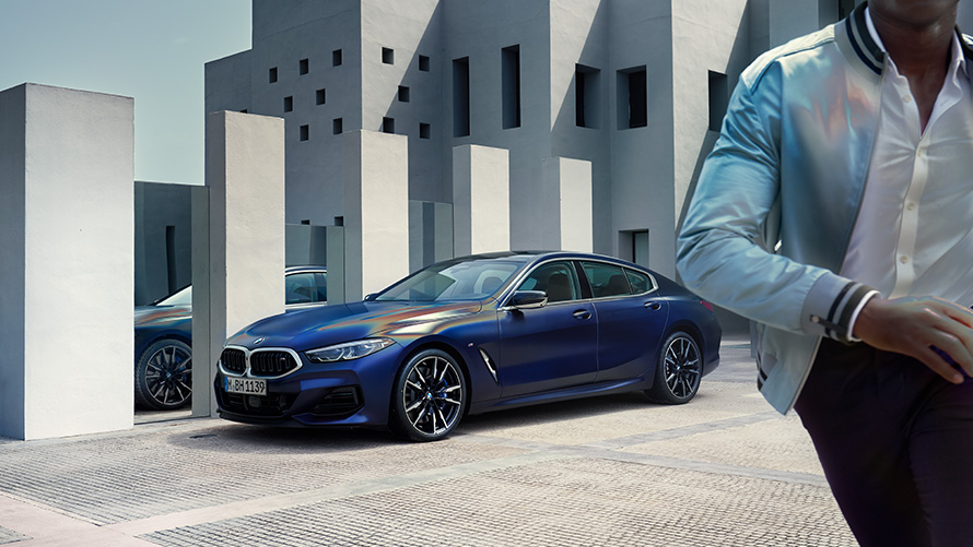 BMW M850i xDrive Gran kupe G16 LCI Facelift 2022 BMW Individual Frozen Tanzanite plava metalik boja tročetvrtinski prednji prikaz vozila sa muškim modelom u prvom planu