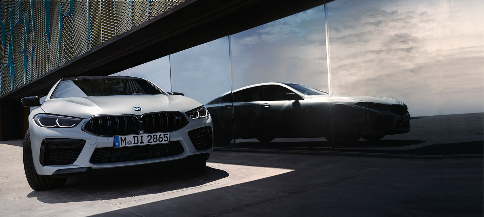 Prednji prikaz BMW M8 Competition Gran kupe F93 LCI Facelift 2022 BMW M8 Competition Gran kupe F93 LCI Facelift 2022 BMW Individual BMW Individual Frozen Brilliant bela metalik boja prednji prikaz sa odrazom siluete na prednjoj strani prozora