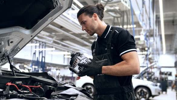 Zaposleni u radionici BMW Value Service drži alternator