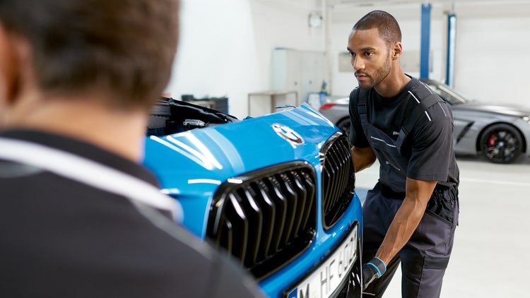 BMW Repair Care, two people installing a BMW face