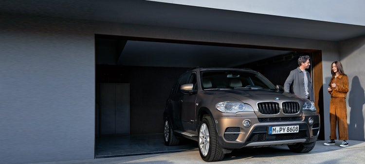 BMW Value Service čovek i žena ispred garaže pored modela BMW X5