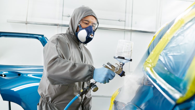 BMW Repair, a person painting a BMW in blue