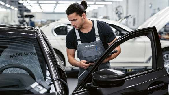 Član osoblja radionice BMW Value Service razgleda unutrašnjost vozila
