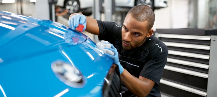 BMW service, a person doing the final polish on a car.